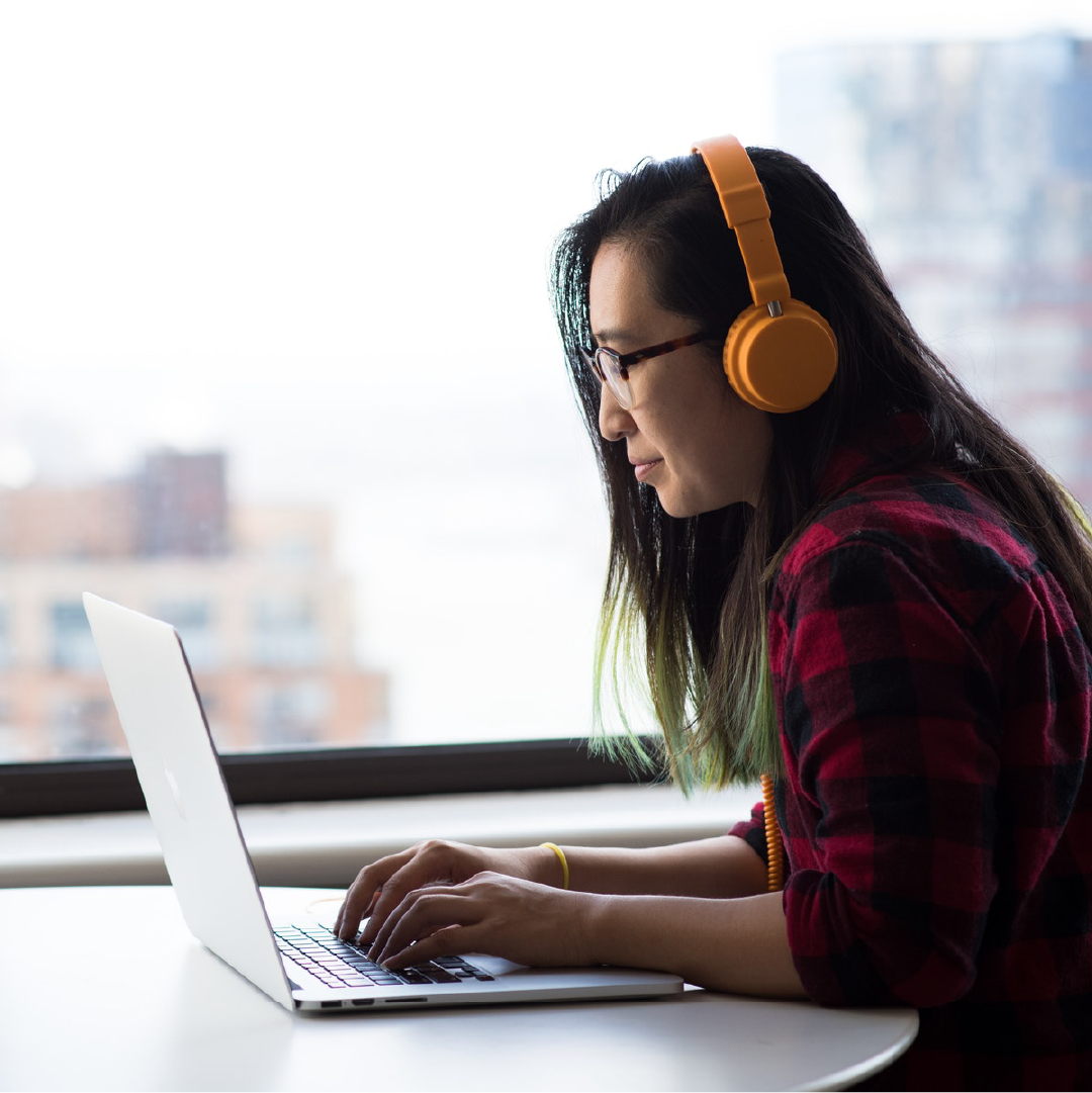 Student wearing headphones on their laptop